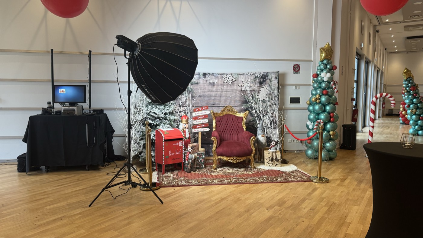 Éclairage de studio et poste d'impression installés devant un décor de Noël lors d'un arbre de Noël d'entreprise