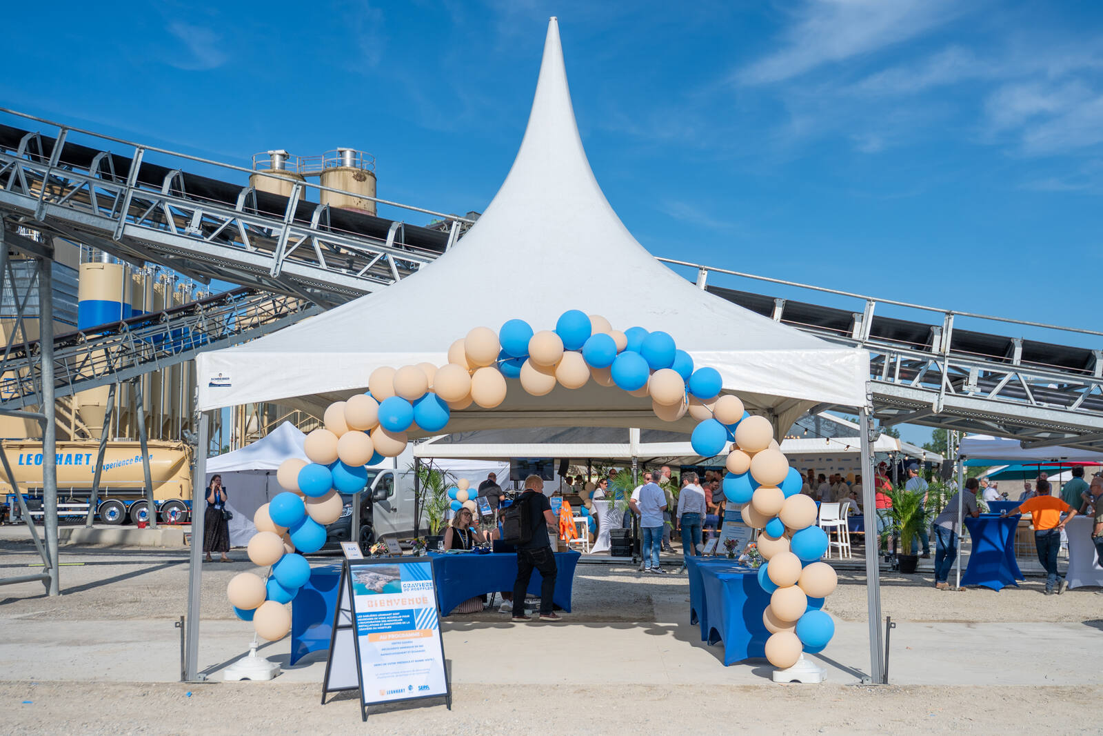 Chapiteau d'accueil et arche de ballons au pied d'installations industrielles